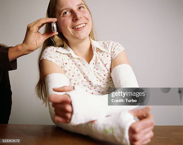 man holding cell phone for woman with broken arms - broken friendship stock pictures, royalty-free photos & images