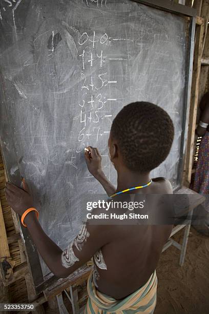 karo boy writing on blackboard during class - hugh sitton ethiopia stock pictures, royalty-free photos & images