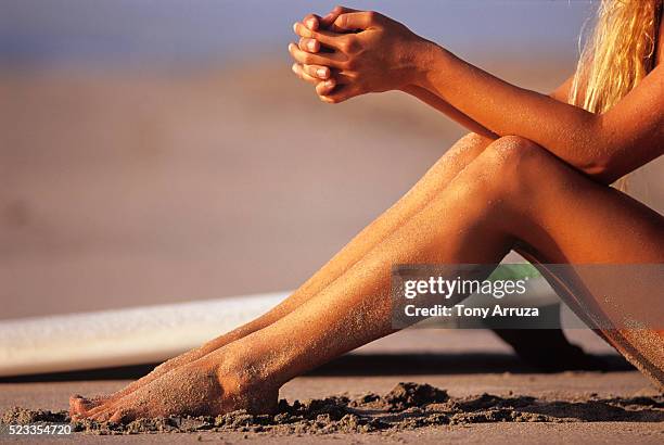 woman surfer sitting on the beach - sitting on surfboard stockfoto's en -beelden