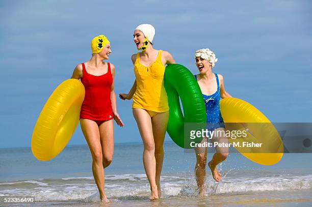 friends in retro swimwear with inner tubes - anos 50 imagens e fotografias de stock