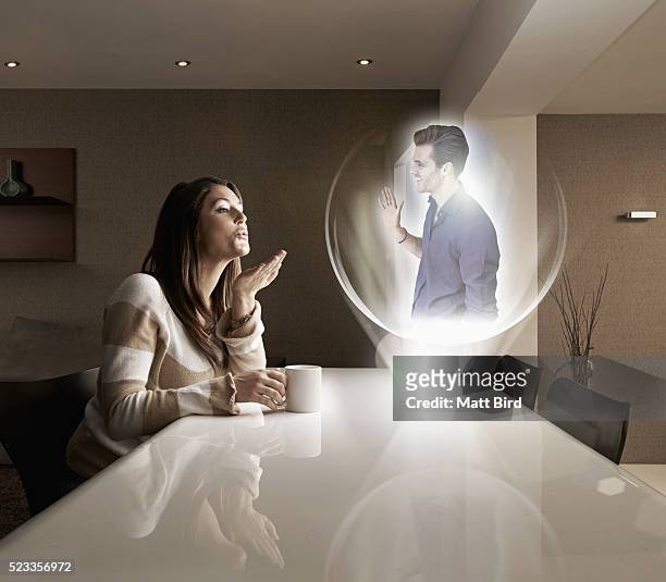 man and woman having a video call using futuristic 3d device - holografie stockfoto's en -beelden