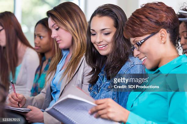 diverse group of women taking notes during seminar - handbook stock pictures, royalty-free photos & images