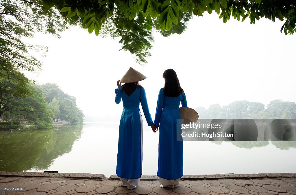 Vietnamese women in traditional costume. Ho Kiem Lake. Hanoi.