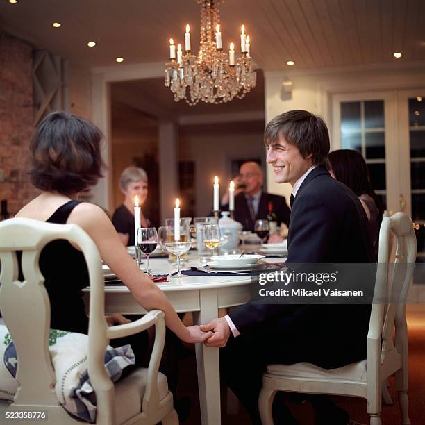 man and woman holding hands at table - festlich gekleidet stock-fotos und bilder
