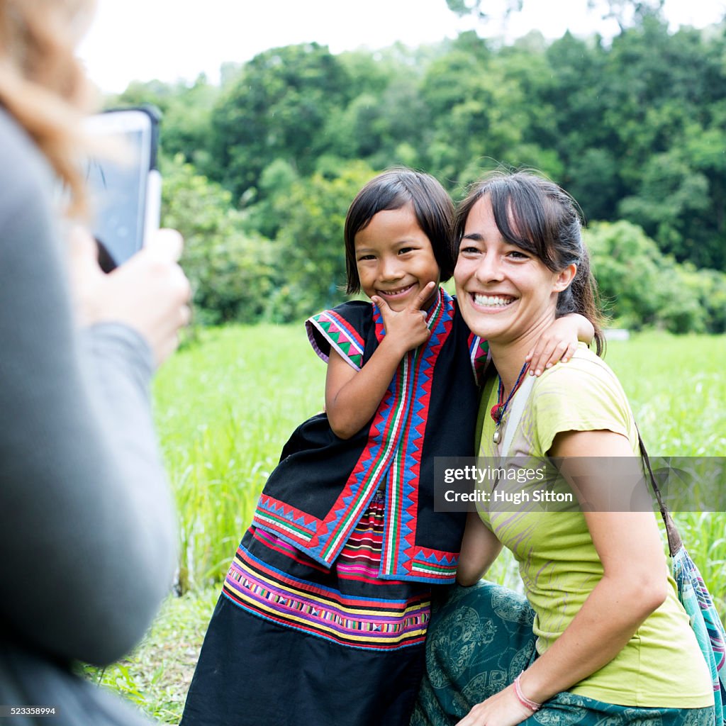 Female tourist and local child (4-5) posing for photo, Chiang Mai, Thailand