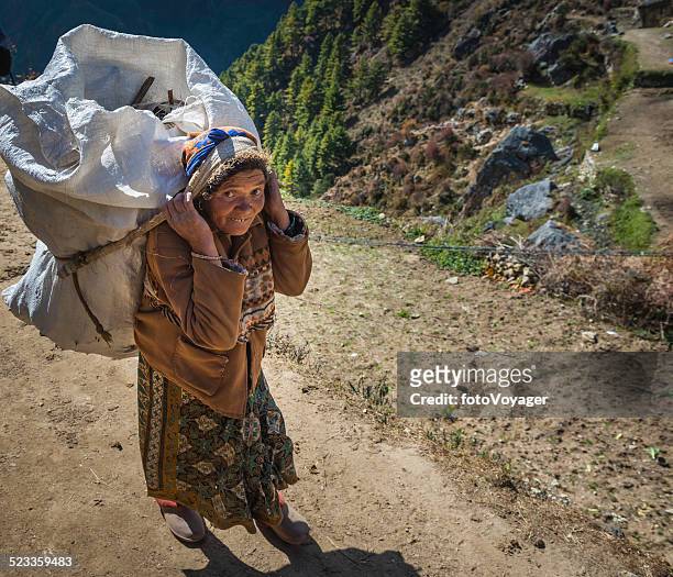 mulher sênior sherpa porter carregando pesados de carga no himalaia nepal - buck teeth - fotografias e filmes do acervo
