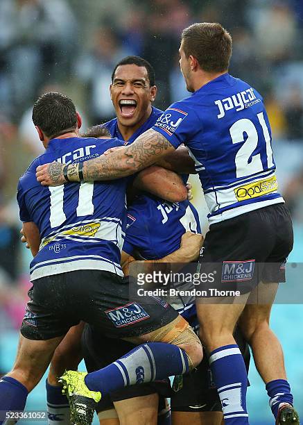 Josh Reynolds of the Bulldogs celebrates with team mates, Will Hopoate, Craig Garvey and Josh Jackson after kicking a field goal for victory over the...