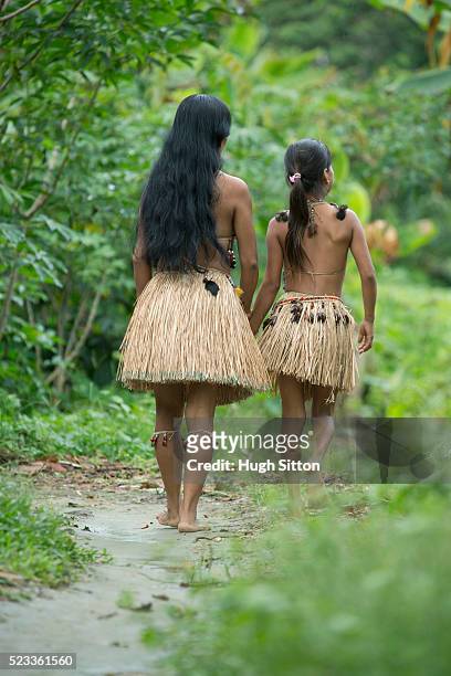 rear view of woman and girl (8-9) in traditional skirts, amazon river basin, ecuador - amazon jungle girl stock-fotos und bilder
