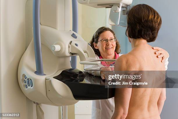 medical technician preparing patient for mammogram - mammogram stock pictures, royalty-free photos & images