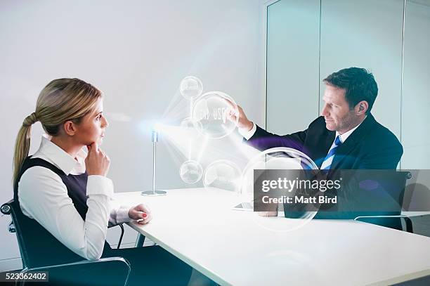 office colleagues looking at 3d projection from futuristic device - virtual presentation stock pictures, royalty-free photos & images