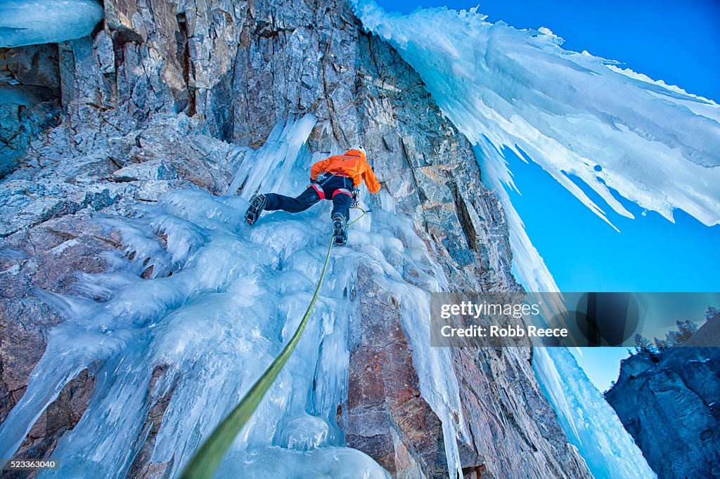 Man ice climbing with rope