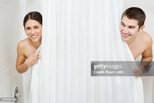 couple hiding behind a shower curtain - symmetry imagens e fotografias de stock