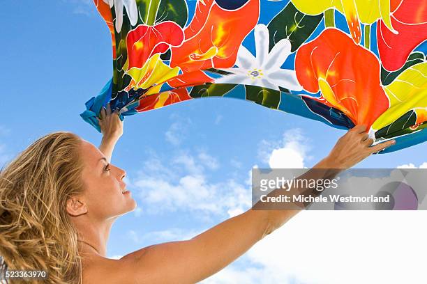 woman holding sarong in breeze - sarong stock-fotos und bilder