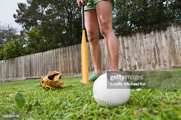 woman with baseball in backyard - backyard baseball stock-fotos und bilder