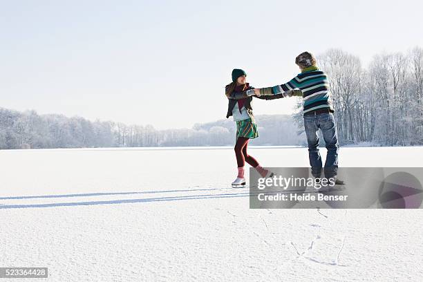 couple ice skating on frozen pond - アイススケート ストックフォトと画像
