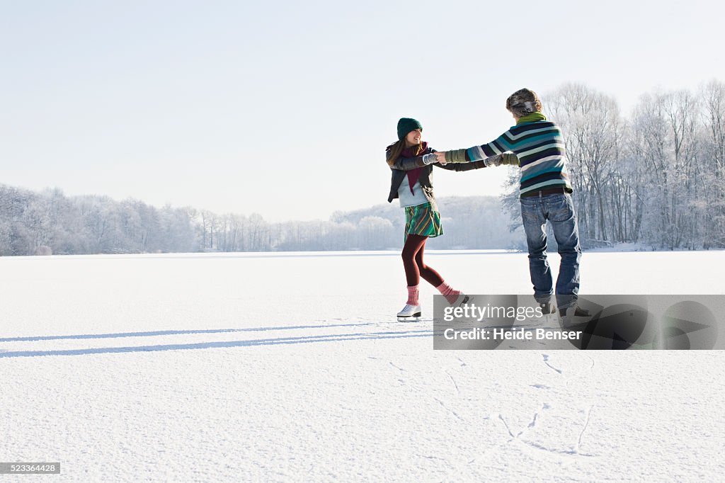 Couple Ice Skating on Frozen Pond