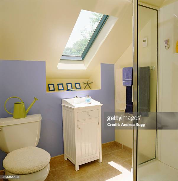 skylight over small cabinet in attic bathroom - light blue tiled floor stock pictures, royalty-free photos & images