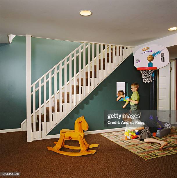 children playing in basement playroom - playroom stock-fotos und bilder