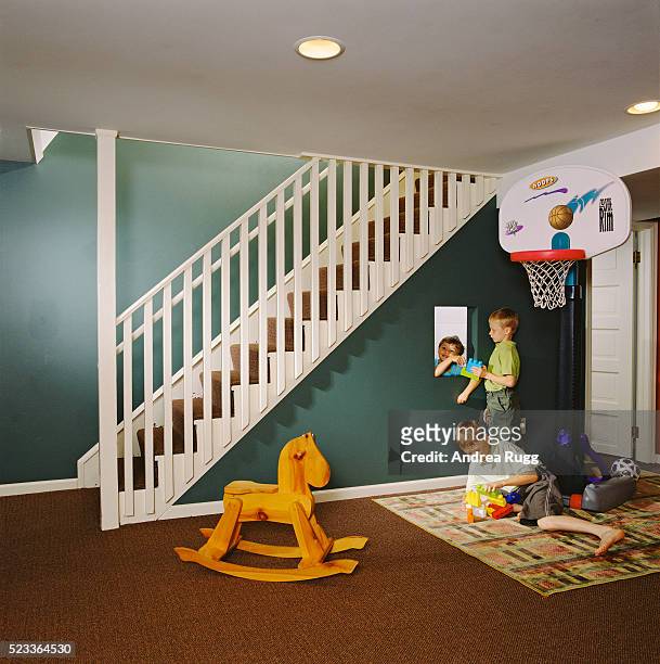 children playing in basement playroom - basement stock pictures, royalty-free photos & images