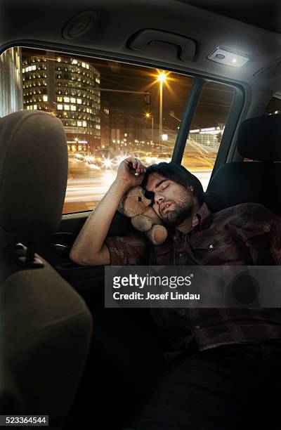 man sleeping in back seat of suv - sleeping in car fotografías e imágenes de stock
