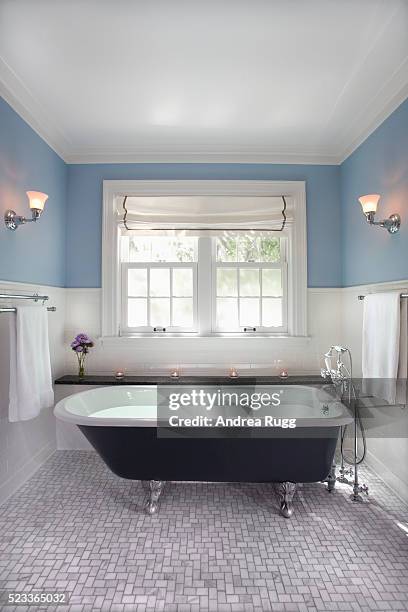 clawfoot tub surrounded with tile wainscoting - blue bathroom stock-fotos und bilder