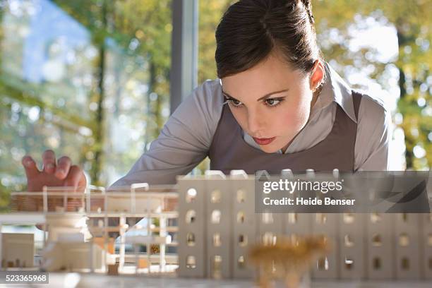 businesswoman studying an architectural model - architect photos et images de collection