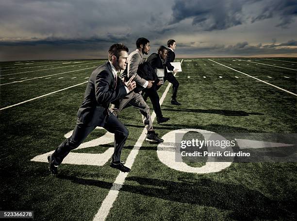 businessmen running on football field - business pitch stock pictures, royalty-free photos & images