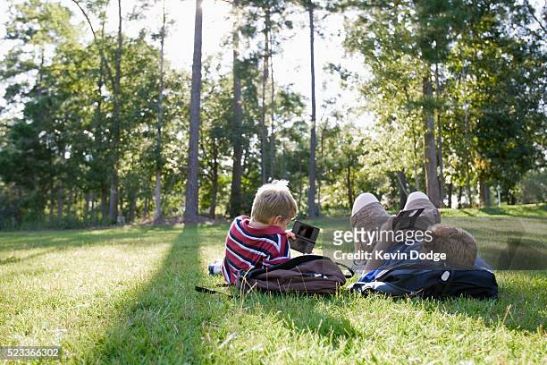 boys playing handheld video games - handheld video game stock pictures, royalty-free photos & images