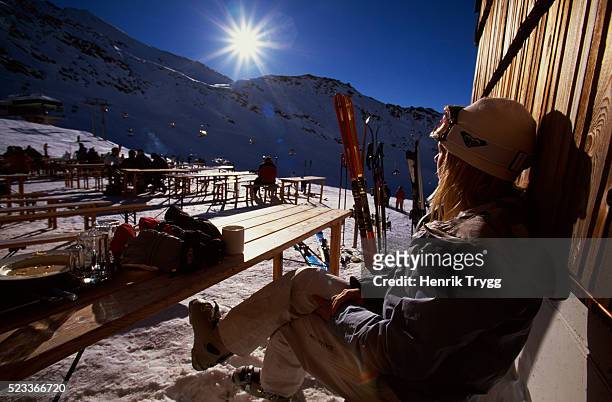 woman sitting on bench at ski resort - ski holidays stock pictures, royalty-free photos & images