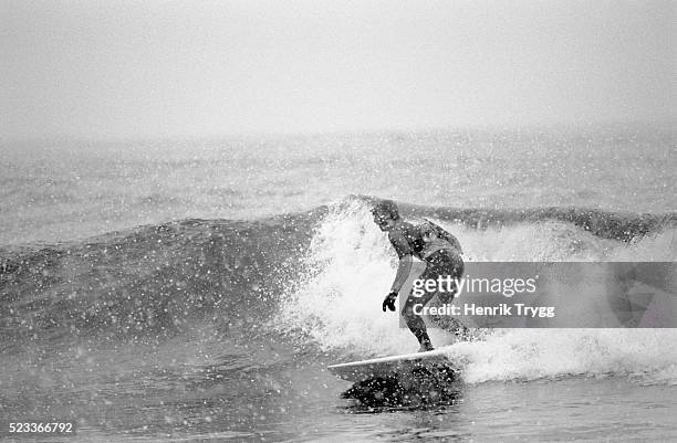 man surfing during snowstorm - vintage surf stock pictures, royalty-free photos & images