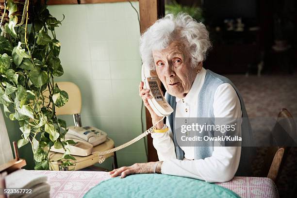 elderly woman talking on the telephone - alleen seniore vrouwen stockfoto's en -beelden