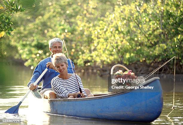 fishing from a canoe - seniors canoeing stock pictures, royalty-free photos & images