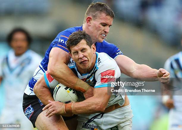 Greg Bird of the Titans receives a high tackle from Tim Browne of the Bulldogs during the round eight NRL match between the Canterbury Bulldogs and...