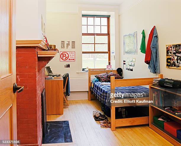 dorm room with brick fireplace and wood floor - dorm room stock-fotos und bilder