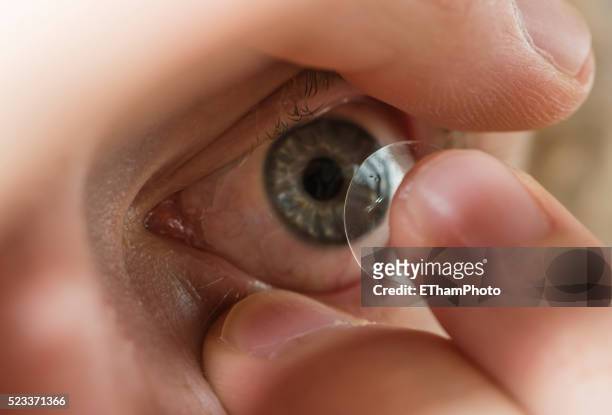inserting contact lens into the eye - contact lens stock pictures, royalty-free photos & images