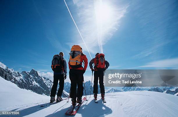 three skiers on top of mountain - garmisch ski stock pictures, royalty-free photos & images