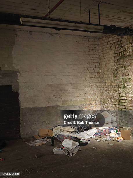 destitute young man sleeping in corner of room - drug addiction stock pictures, royalty-free photos & images