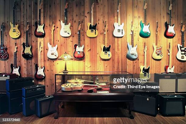 electric guitars and amplifiers in music store - rockmuziek stockfoto's en -beelden