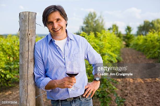 grape farmer standing in a field with a glass of wine - jim farmer stock pictures, royalty-free photos & images