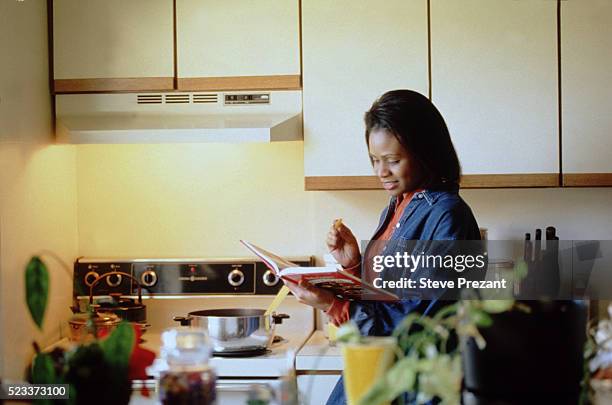 woman cooking in kitchen - cooking cookbook stock pictures, royalty-free photos & images