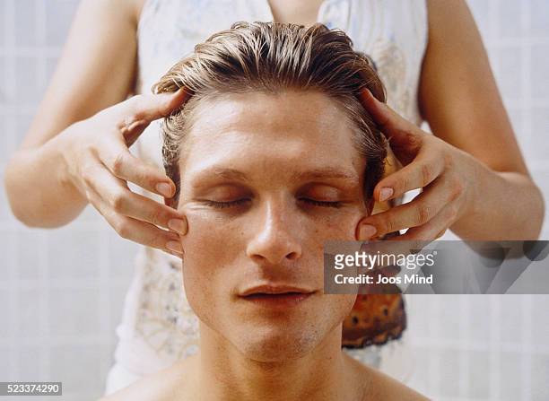 young man receiving head massage - verwöhnen stock-fotos und bilder