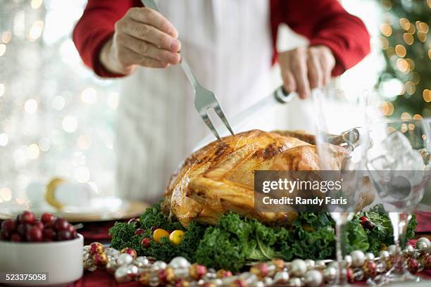 man carving turkey for holiday dinner - skära mat bildbanksfoton och bilder