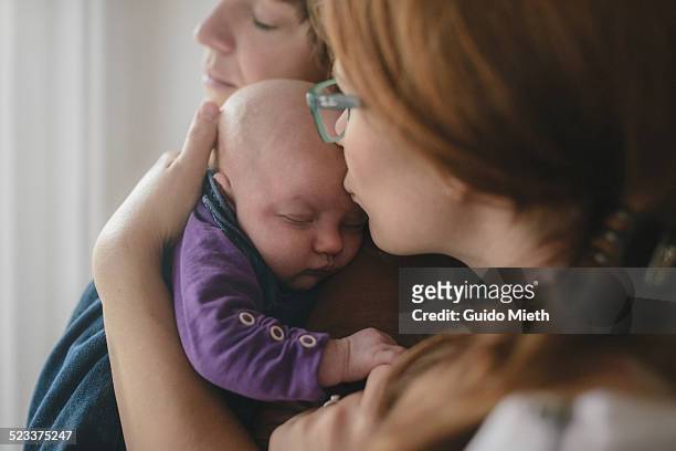 lesbian couple with newborn child. - two parents stock-fotos und bilder