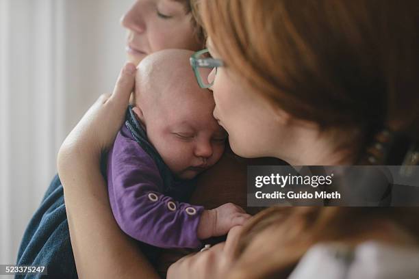 lesbian couple with newborn child. - lesbische stockfoto's en -beelden