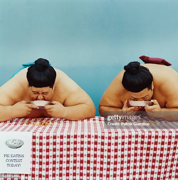 sumo wrestlers in pie eating contest - sumo stock pictures, royalty-free photos & images