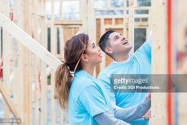 couple working together to build home for charity - volunteer building stock pictures, royalty-free photos & images