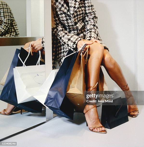 woman sitting with shopping bags - sezione inferiore foto e immagini stock