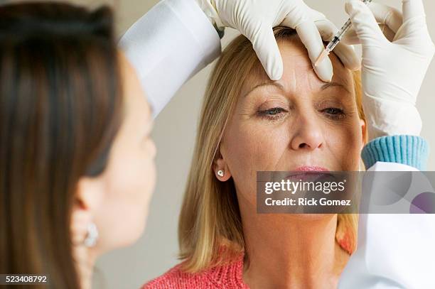 woman receiving botox injection - chirurgia plastica foto e immagini stock