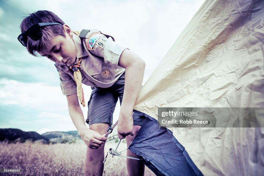 A Boy Scout sets up a camping tent at Boy Scout camp in Colorado.