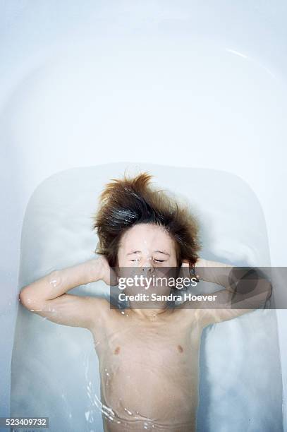 boy ( 8-9 ) diving in bathtube - bathtube stock pictures, royalty-free photos & images